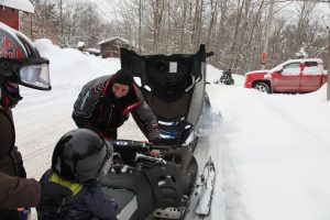 snowmobile with hood open, adding oil