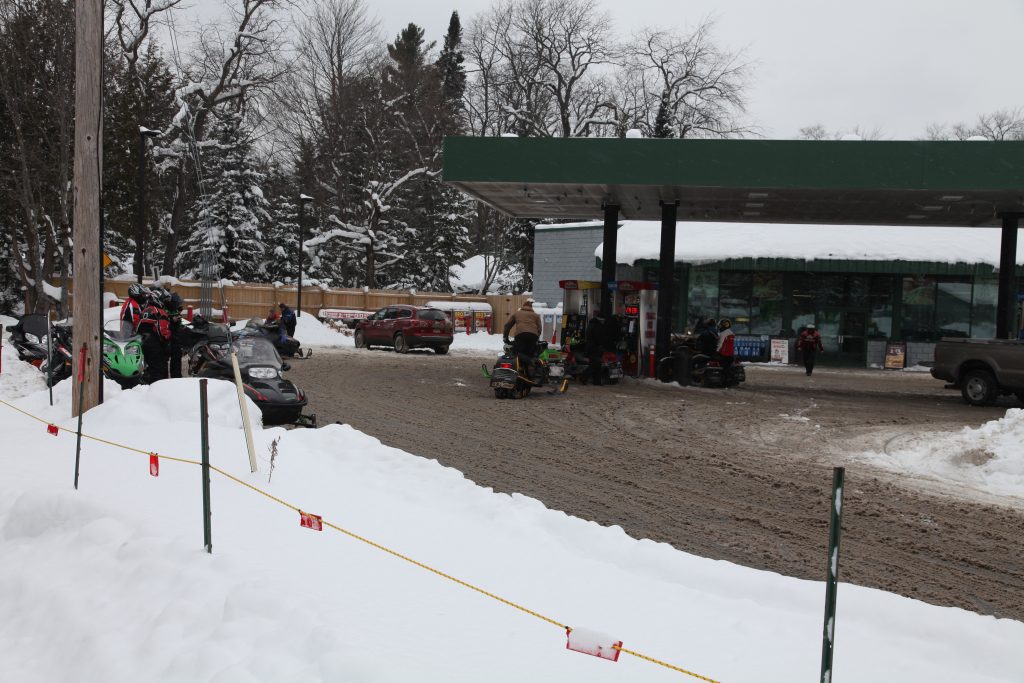 Cars and snowmobiles getting fuel