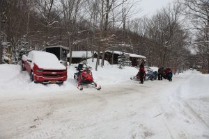 a truck in the snow and snowmobiles