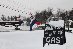 sign for a gas station with OPEN flag