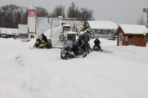snowmobiles fueling up at temporary fuel station